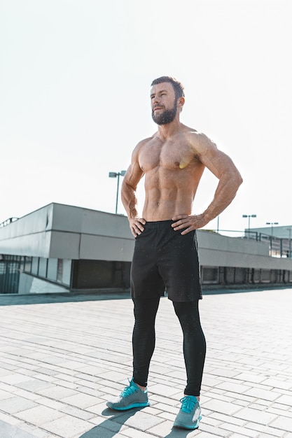 Ajuste fitness hombre posando en la ciudad