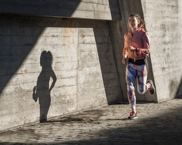 Ajuste hembra joven corriendo al aire libre