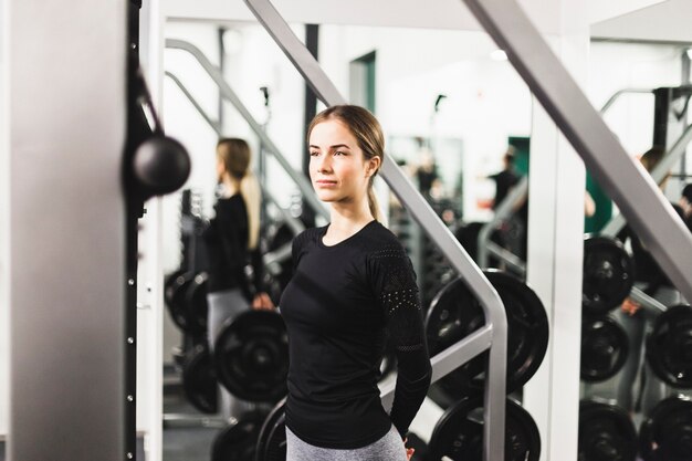 Ajuste joven mujer de pie en el gimnasio