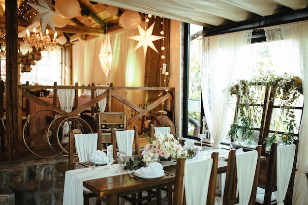 Foto gratuita ajuste de la mesa con centro floral en el lugar de recepción de bodas.