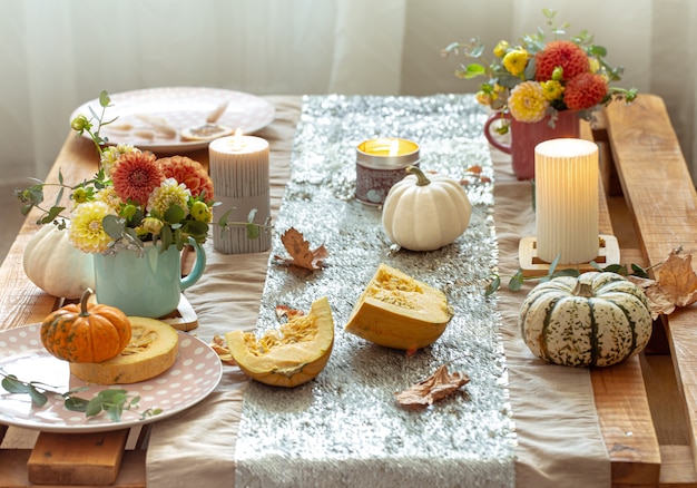 Ajuste de la mesa festiva con calabazas y flores de crisantemo