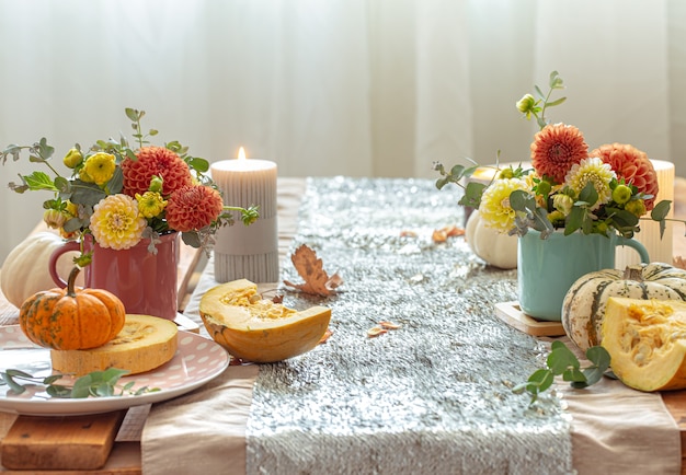 Ajuste de la mesa festiva con calabazas y flores de crisantemo