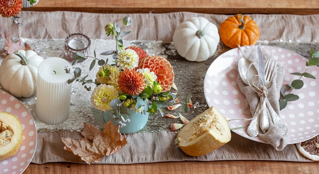 Ajuste de la tabla festiva con velas de calabazas y flores de crisantemo