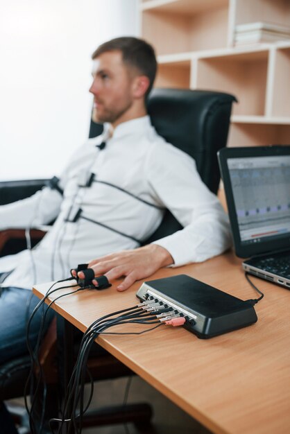 Al joven empresario no le gustan sus empleados. Hoy sabremos si eso es cierto. Hombre sospechoso pasa el detector de mentiras en la oficina. Haciendo preguntas