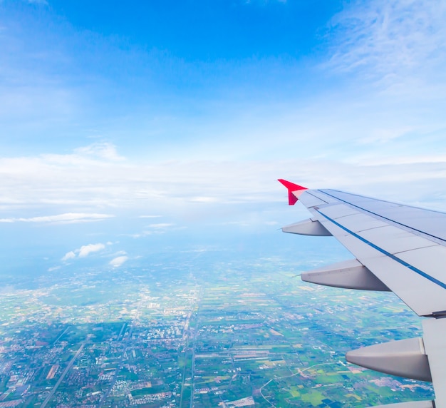 Ala de un avión con una ciudad de fondo