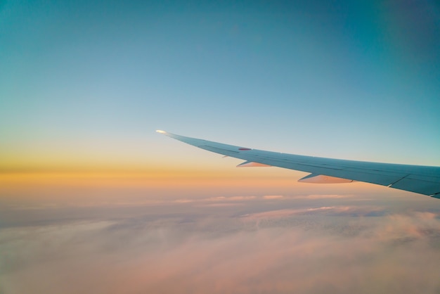 Foto gratuita ala de un avión volando por encima de las nubes