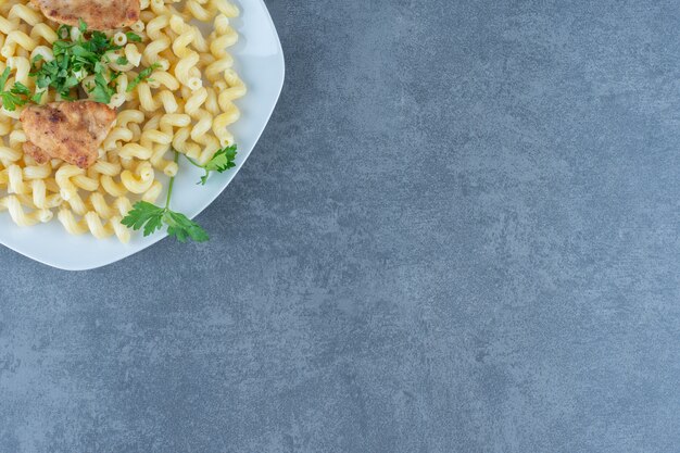 Alas de pollo a la plancha sobre pasta hervida.