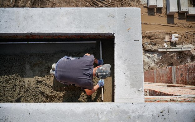 Albañil trabajando con arena y haciendo paredes al aire libre