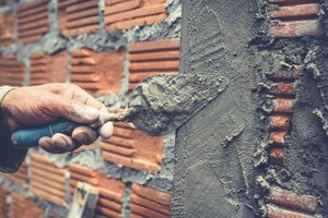 Foto gratis albañilería trabajador de la construcción construyendo una pared de ladrillos.