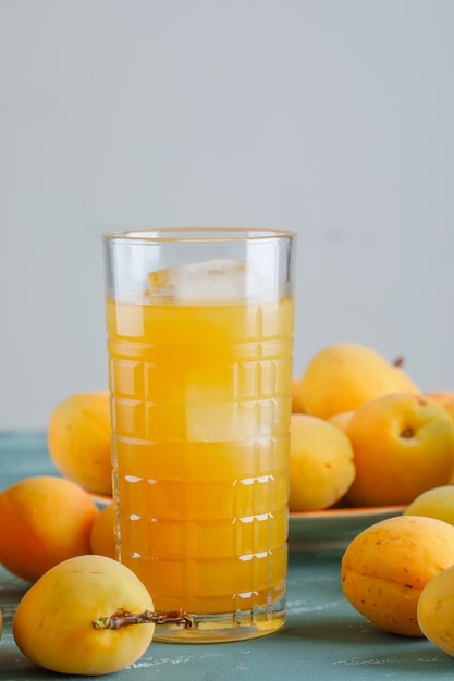 Albaricoques con jugo en un plato, vista lateral.