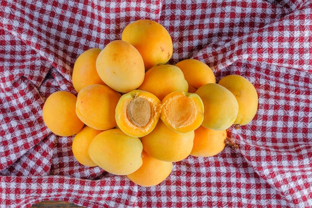 Foto gratuita albaricoques en un paño de picnic. aplanada