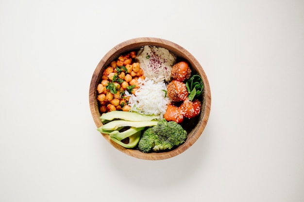 Albóndigas, arroz, frijoles y brócoli dentro de un tazón de madera.