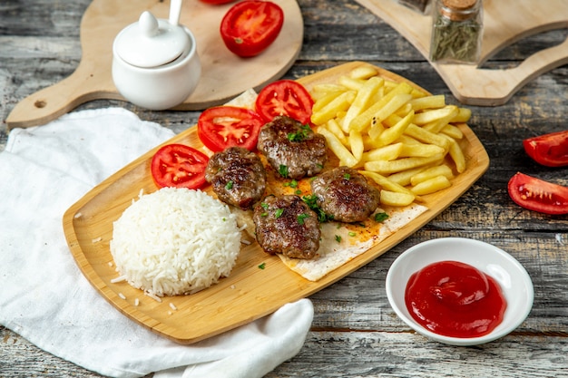 Albóndigas fritas con arroz papas fritas vista lateral