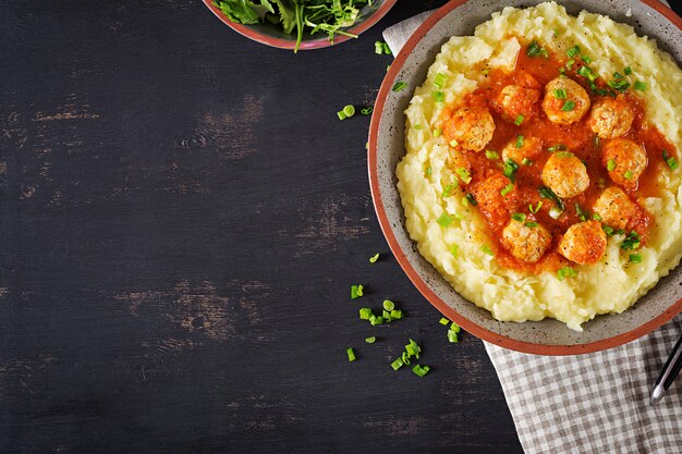 Albóndigas en salsa de tomate con puré de papas en un tazón.