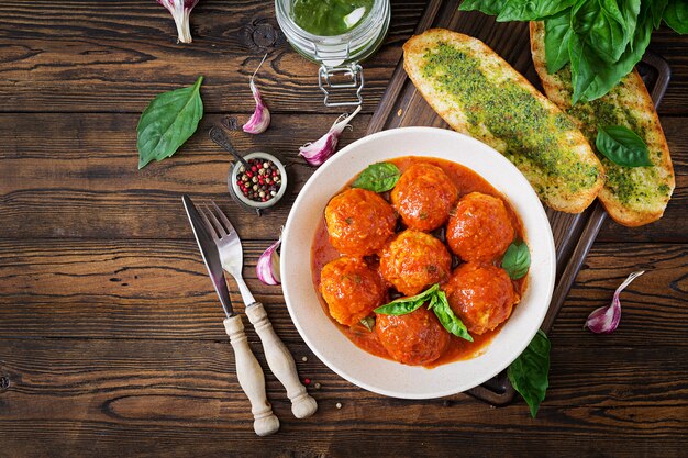 Albóndigas en salsa de tomate y tostadas con pesto de albahaca.