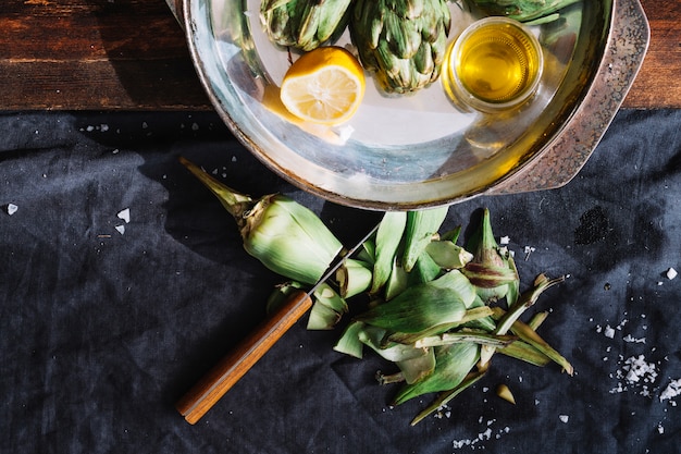 Foto gratuita alcachofa cerca de la bandeja con limón y aceite