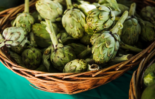 Alcachofas frescas en mimbre en el mercado de agricultores