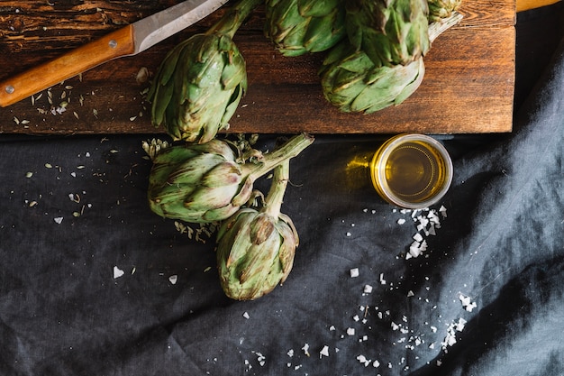 Foto gratuita alcachofas y vaso de aceite