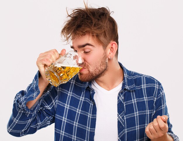 Alcohol. Chico de camisa azul con cerveza