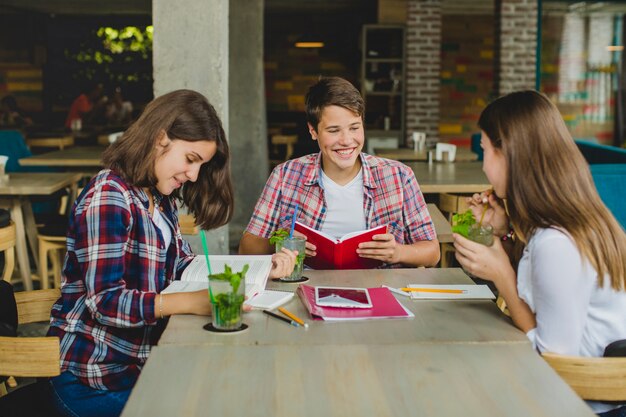 Alegre adolescentes con libros en el café