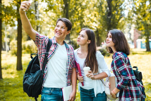 Alegre amigos tomando selfie en el parque