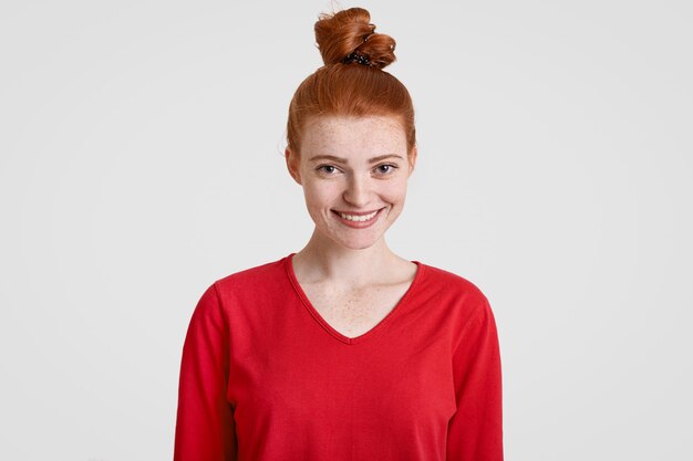 Alegre atractivo adolescente con nudo de pelo de jengibre, piel pecosa, estar de buen humor como tiene cita con su novio