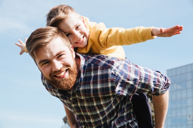 Alegre barbudo padre divirtiéndose con su pequeño hijo