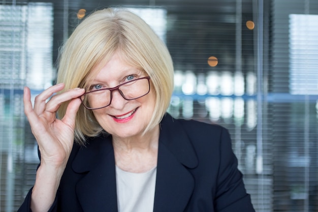 Foto gratuita alegre dama de éxito de ajuste de gafas