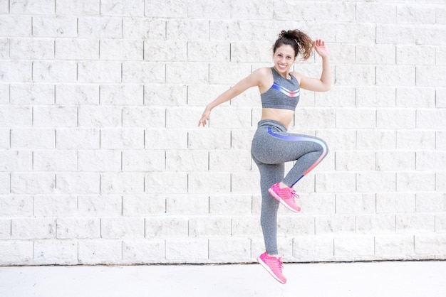 Alegre, deportivo, mujer, saltar, cerca, pared