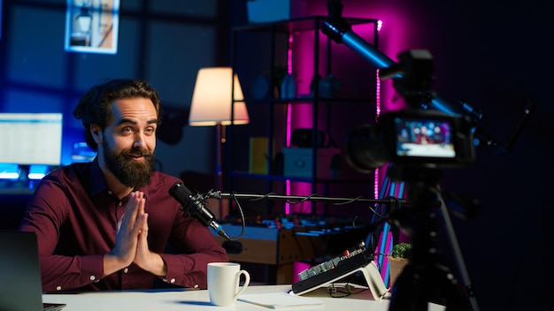 Alegre estrella de los medios hablando en un micrófono profesional en el estudio