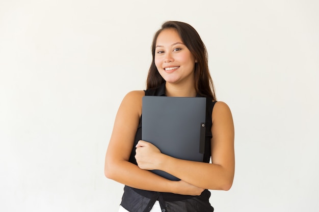 Alegre estudiante con carpeta sonriendo a la cámara