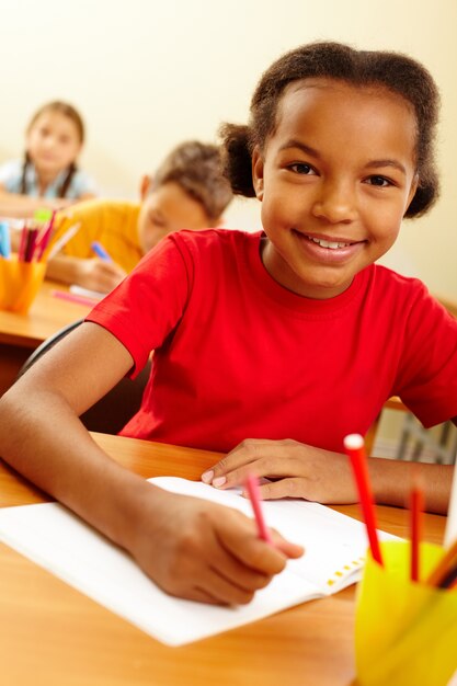 Alegre estudiante dibujando en su cuaderno