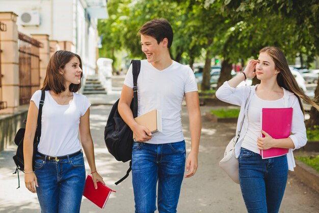 Alegre estudiantes caminando en el parque