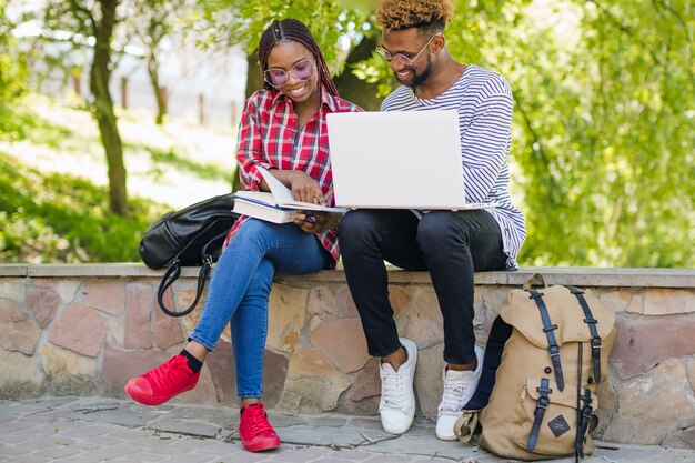 Alegre estudiantes negros estudiando juntos