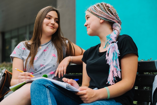 Foto gratuita alegre estudiantes posando en el banco