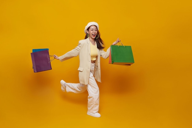 Foto gratuita alegre feliz mujer asiática tailandesa disfrutando de las compras ella está llevando bolsas de compras y saltando