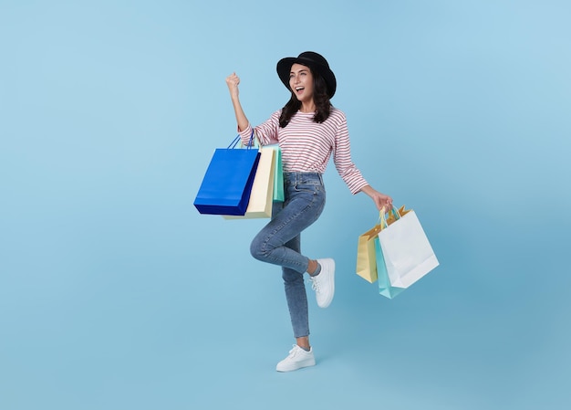 Alegre feliz mujer asiática tailandesa disfrutando de las compras, lleva bolsas de compras y celebración