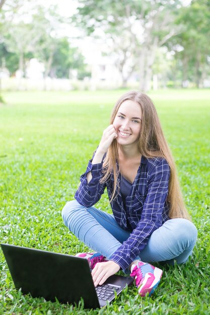 Alegre freelance trabajando en el parque de verano