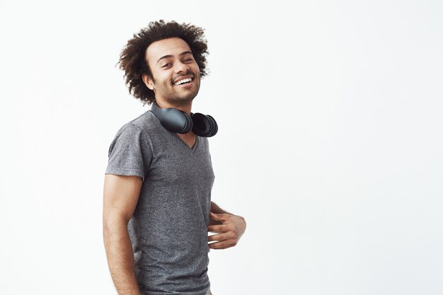 Alegre hombre africano con auriculares sonriendo