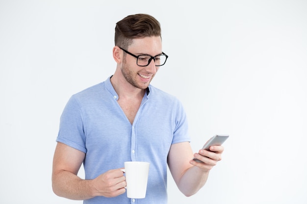 Alegre hombre inteligente lectura de mensajes en el teléfono