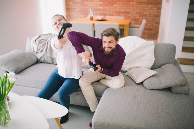 Alegre hombre y mujer jugando consola