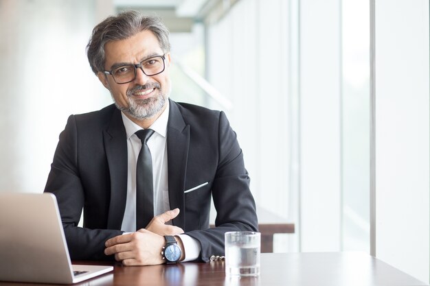 Alegre hombre de negocios en gafas en la oficina