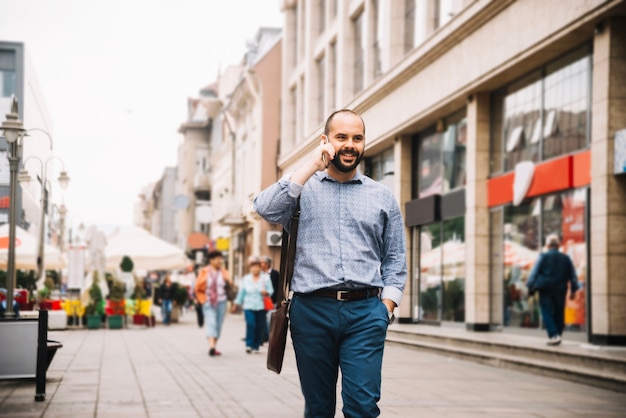 Foto gratuita alegre hombre seguro hablando por teléfono