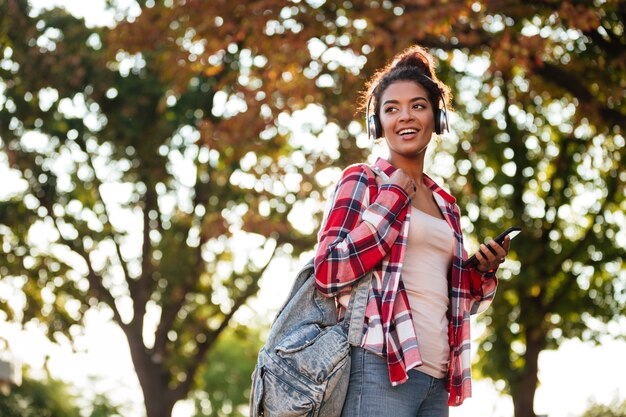 Alegre joven africana caminando al aire libre