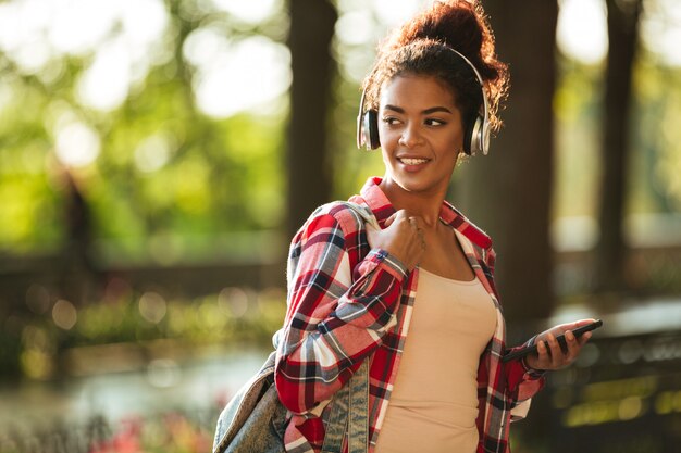 Alegre joven africana caminando al aire libre