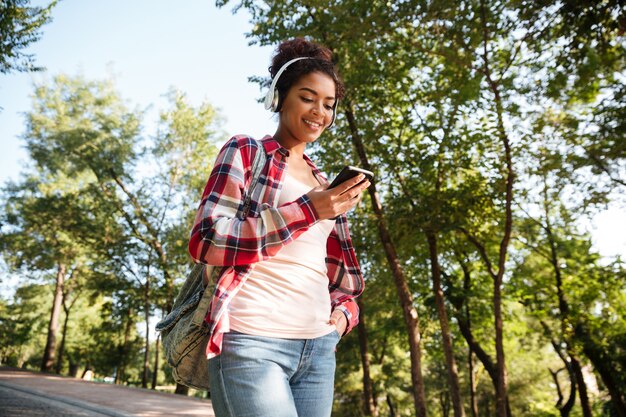 Alegre joven africana caminando al aire libre