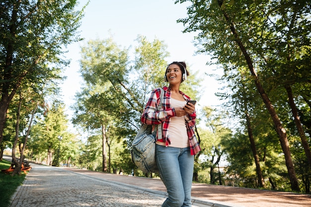 Alegre joven africana caminando al aire libre