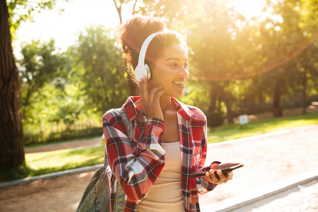 Foto gratuita alegre joven africana caminando al aire libre