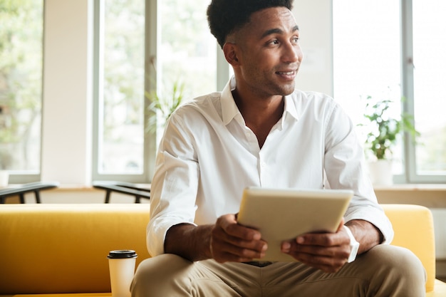 Alegre joven africano sentado coworking