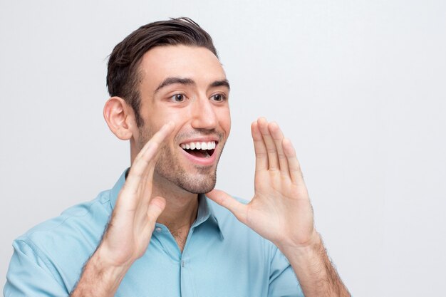 Alegre joven apuesto hombre va a gritar fuerte